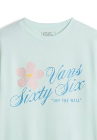 Svetle mátové tričko s krátkým rukávem, které obsahuje grafiku růžové květiny, modrý text "Vans Sixty Six" a tučné "OFF THE WALL".