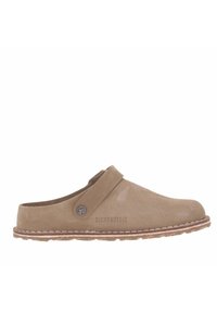 Zoccoli in suede marrone con una larga fascia regolabile, punta tonda, superficie testurizzata e cuciture bianche. Presentano un accento con logo circolare sul lato.