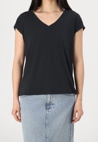 Černé tričko s v-neck výstřihem a krátkými ohrnutými rukávy, vyrobené z měkké látky, v kombinaci s světle modrou denimovou sukní. Jednoduchý design, pohodlný střih.