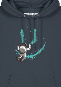 Dunkelblaue Kapuzenjacke mit einem Astronautenmotiv in Weiß und Türkis, umgeben von Sternen und Spritzmustern. Kordeln mit silbernem Zubehör.