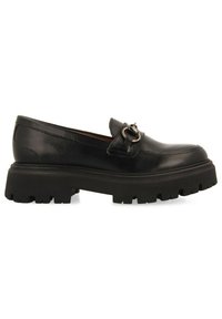 Mocassin en cuir noir avec un bout rond, accent en boucle métallique, et une semelle épaisse texturée avec des rainures profondes pour une meilleure adhérence.