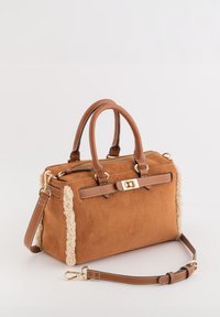 Sac à main en daim marron avec accents en fourrure crème, poignées supérieures, bandoulière amovible et ferrures dorées. Forme rectangulaire avec fermeture éclair.