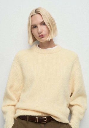 Suéter de punto amarillo claro con cuello redondo y mangas largas. Confeccionado en material suave, presenta un corte relajado y detalles acanalados.