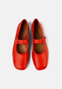 Scarpe Mary Jane in pelle rossa con punta arrotondata, cinturino con fibbia e finitura liscia; all'interno presenta il logo 'Camper' stampato in marrone.