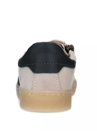 Vista posteriore di una sneaker con un upper in suede beige chiaro, cappuccio del tallone in gomma nera e suola color gomma. Presenta un design con lacci e dettagli in metallo.