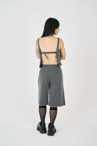 Grå tvådelad outfit som består av en kort backless topp med justerbara axelremmar och skräddarsydda knälånga shorts med fickor.
