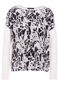 Top à manches longues avec un motif floral noir sur fond blanc, fabriqué en tissu doux, avec une coupe décontractée et un large col.