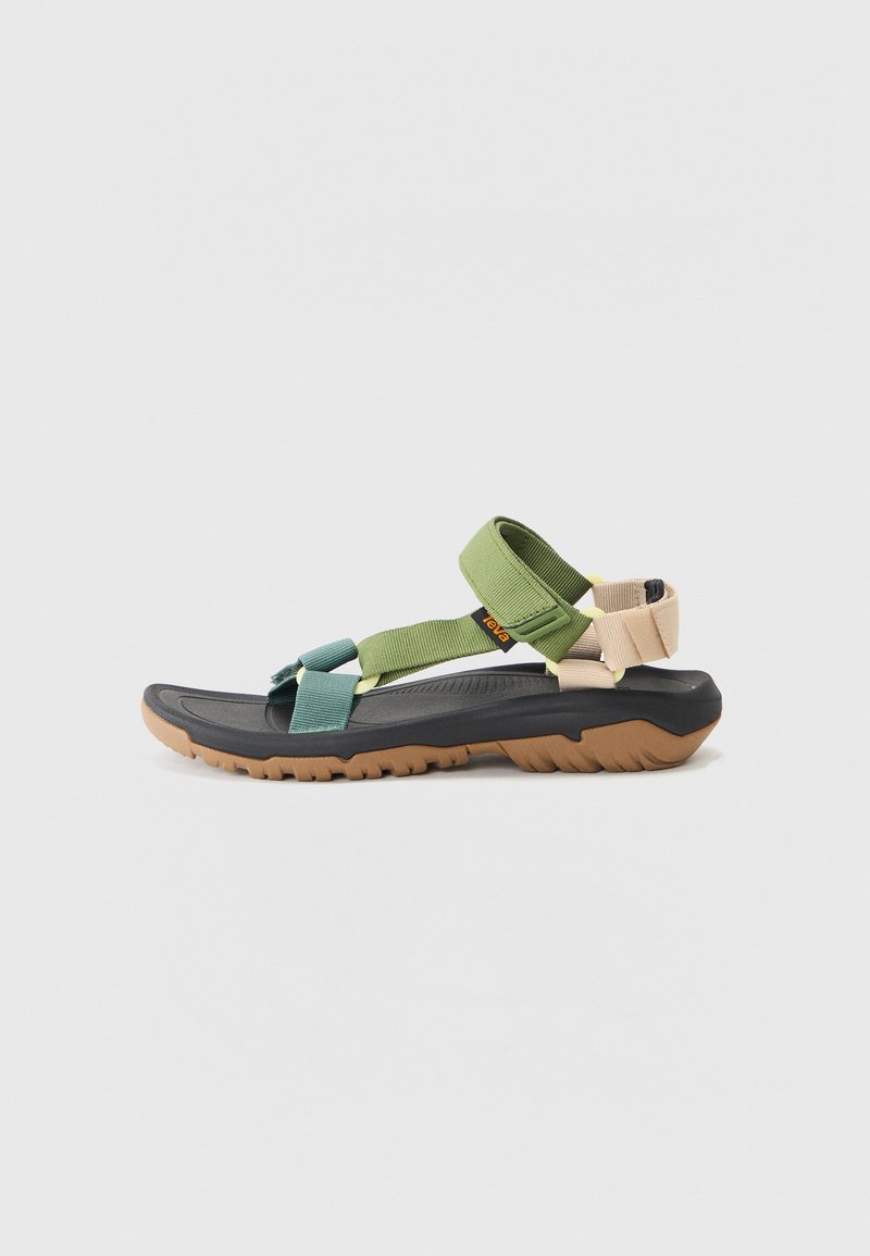 Adjustable sandal featuring a black rubber sole, multicolored fabric straps in green, teal, and beige, and textured footbed for grip.