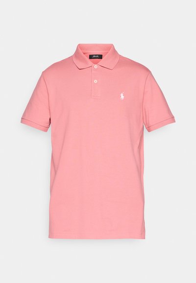 Pink cotton polo shirt with a collar, short sleeves, and two buttons. Features a white embroidered logo on the left chest. Smooth texture.