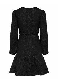 Svart långärmad klänning med ett texturerat blommönster, en utsvängd nederdel och en dragkedja bak. Tyget verkar lätt och mönstrat.