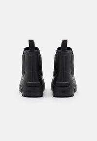 Bottes noires à la cheville avec une finition brillante, panneaux latéraux élastiques et languettes à l'arrière. Semelle en caoutchouc texturé pour une adhérence et une durabilité.