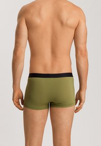 Bóxer ajustados para hombre en verde oliva con una cinturilla negra, diseño ajustado y textura suave, mostrando la vista trasera.