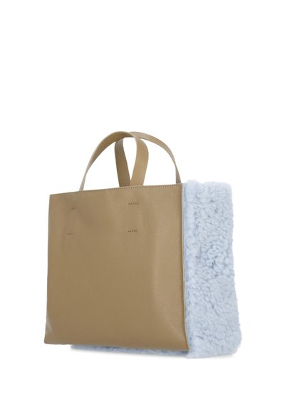 Borsa tote in pelle tan con un lato in morbida pelliccia sintetica azzurro chiaro. Presenta due manici robusti e dettagli di cucitura minimi sul davanti.