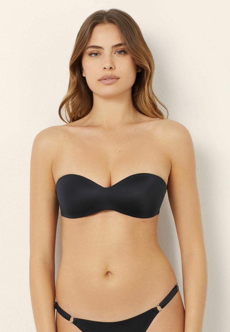 Black strapless bikini top with a smooth texture, molded cups, and a subtle sheen. Paired with matching bikini bottoms featuring side accents.