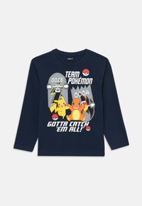 Tengerészkék hosszú ujjú póló Pikachúval és Charmanderrel, két skateboarddal, Poké golyókkal és a "Team Pokémon Gotta Catch 'Em All!" felirattal.
