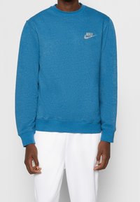 Felpa blu con girocollo realizzata in tessuto morbido, con maniche lunghe e un piccolo logo ricamato sul lato sinistro del petto.