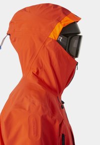 Cazadora impermeable de color naranja brillante con capucha y detalles en naranja. Cuenta con cremalleras y un logo RECCO® en el costado, diseñada para uso en exteriores.