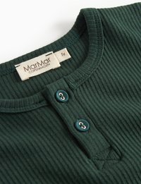 Musta vihreä ribattua puuvillapaitaa, jossa on pyöreä pääntie ja kaksi vastaavaa nappia, merkitty MarMar Copenhagen, koko 5 vuotta.