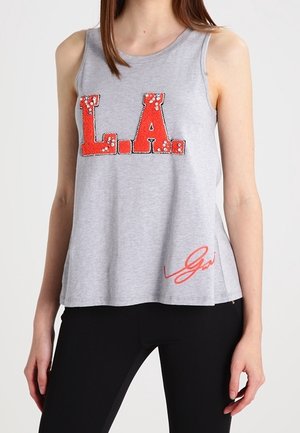 Szary top bez rękawów z napisem "L.A." w czerwonych cekinach oraz kontrastującym czerwonym akcentem sygnaturowym na dole. Luźny krój, miękki materiał.