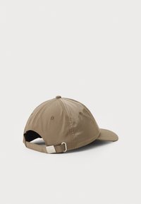 Tan baseballcaps laget av lett stoff; har en justerbar stropp og metallspenne bak, med minimalistisk design.