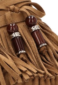 Bolso de ante marrón que presenta dos acentos decorativos con cuentas marrones oscuras y bandas de plata. El bolso tiene detalles con flecos a lo largo de los bordes.