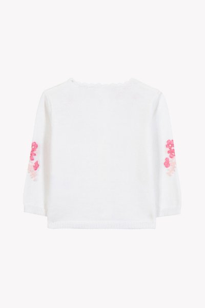 Λευκό πλεκτό πουλόβερ με μακριά μανίκια, διακοσμημένο με ροζ κεντήματα λουλουδιών σε κάθε μανίκι και στρογγυλεμένο ντεκολτέ. Μαλακή υφή, καθημερινό σχέδιο.