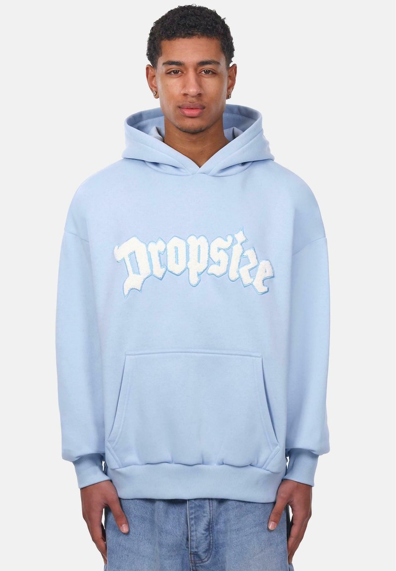 Helle blaue Kapuzenjacke aus weichem Baumwollmaterial. Verfügt über eine Fronttasche, gerippte Bündchen und einen kräftig gestickten "Dropsize"-Text in kontrastierenden Farben.