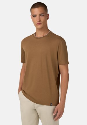 T-shirt marrone a maniche corte realizzato in un tessuto morbido, con scollo rotondo rifinito con un bordo a contrasto e una piccola etichetta del marchio all'orlo.