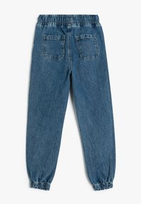 Pantalones jogger de denim con una cinturilla elástica, puños ajustados y dos bolsillos en la parte posterior. Presentan un lavado azul medio y una textura ligeramente desgastada.