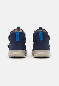 Marineblaue High-Top-Schuhe mit zwei Klettverschlüssen, beigem Innenfutter, kontrastierenden blauen Akzenten und einer strukturierten beigen Sohle.