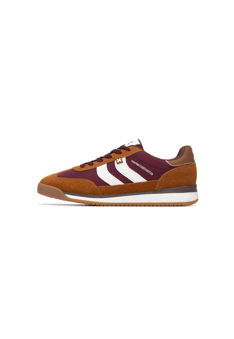 Zapatillas con cordones de ante marrón y cuerpo de textil burdeos. Presentan franjas blancas, detalles de cuero marrón y una suela de goma.
