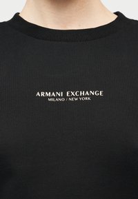 Μαύρο βαμβακερό φούτερ με ριμπ λαιμόκοψη και εκτύπωση λευκού λογότυπου "ARMANI EXCHANGE MILANO / NEW YORK". Απλός σχεδιασμός, χωρίς σχέδια.