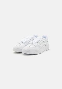 Sneakers atletici bianchi con tomaia in pelle liscia, suola in gomma gommata, design con lacci e discreti dettagli di cucitura. Tacco piatto.