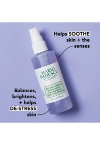 Ansiktssprayflaske med aloe, kamille og lavendel på lilla bakgrunn, merket for å berolige, lysne, balansere og avstresse huden.