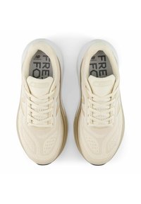 Scarpe da corsa beige con parte superiore in rete, accenti testurizzati e suola ammortizzata. Logo e lacci bianchi con design leggero.