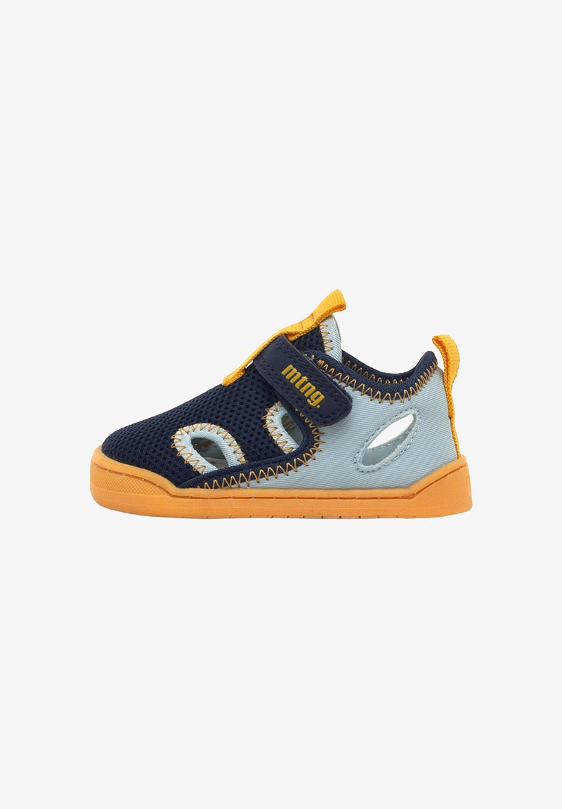Chaussure d'enfant avec une tige en maille marine, des accents bleu clair, une semelle orange et une sangle Velcro. Comprend des découpes pour la respirabilité et la flexibilité.