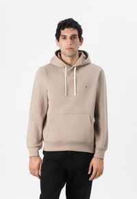 Beżowa bluza z kapturem wykonana z miękkiego materiału, z przednią kieszenią, kapturem ze sznurkiem oraz małym logo na klatce piersiowej. Prosty, klasyczny design.