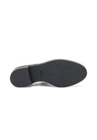 Soletta nera con grip testurizzato, punta arrotondata e profilo liscio. Materiale flessibile e design minimale senza motivi o accenti.