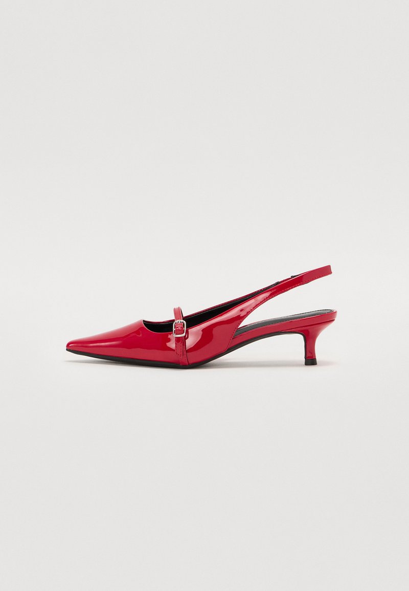 Sandal com salto em verniz vermelho, com bico fino e salto pequeno. Apresenta um detalhe de fivela na alça e um acabamento brilhante.