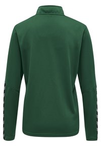 Suéter verde de manga larga con una tela texturizada, cuello alto y rayas contrastantes en blanco y negro a lo largo de las mangas.