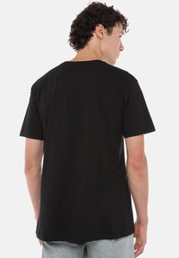 Black cotton t-shirt with short sleeves, crew neck, and a straight hem, showcasing a plain design with no visible logos or patterns.