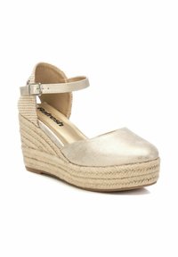 Espadrille dorada con plataforma de yute texturizado, punta redonda y correa al tobillo con hebilla metálica y parte trasera estampada.