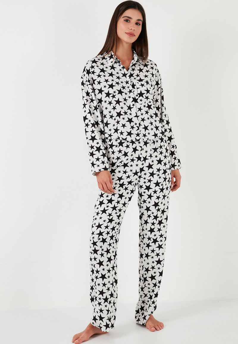 Ensemble de pyjama noir et blanc à motifs d'étoiles avec une chemise à boutons à manches longues et un pantalon assorti, fabriqué en tissu doux.