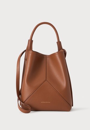 Sac à main en cuir marron avec une poignée supérieure et une longue bandoulière, présentant des coutures angulaires et un petit texte doré "Victoria Beckham" à l'avant.