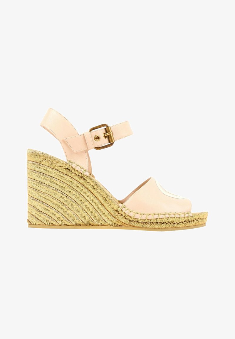 Sandale compensée en cuir beige avec bride à la cheville et boucle en laiton, dotée d’un talon plateforme à texture de corde tissée.