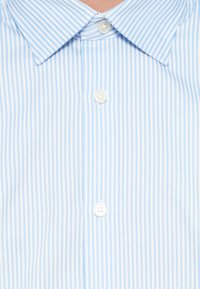 Camisa de riscas azuis claras e brancas com botões, apresentando uma gola clássica, três botões brancos e textura de tecido suave.