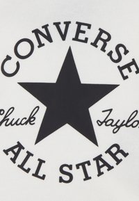 Svart tekst som sier "CONVERSE ALL STAR" omgir en stor svart stjerne på hvit bakgrunn, med "Chuck" og "Taylor" i kursiv.