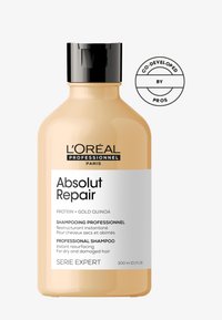 L'Oréal Professionnel Absolut Repair schampo i en persikofärgad flaska, svart kork, med en vit etikett som beskriver fördelarna för hårvård. 300 ml.