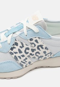 Světlomodré a šedé tenisky s leopardím potiskem, semišovými a textilními materiály, kulatým tvarem a bílými tkaničkami.