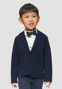 Marineblazer met twee frontzakken, knoopsluiting en opstaande revers. Draag het over een wit shirt met een strikje en een subtiel dierenprint.